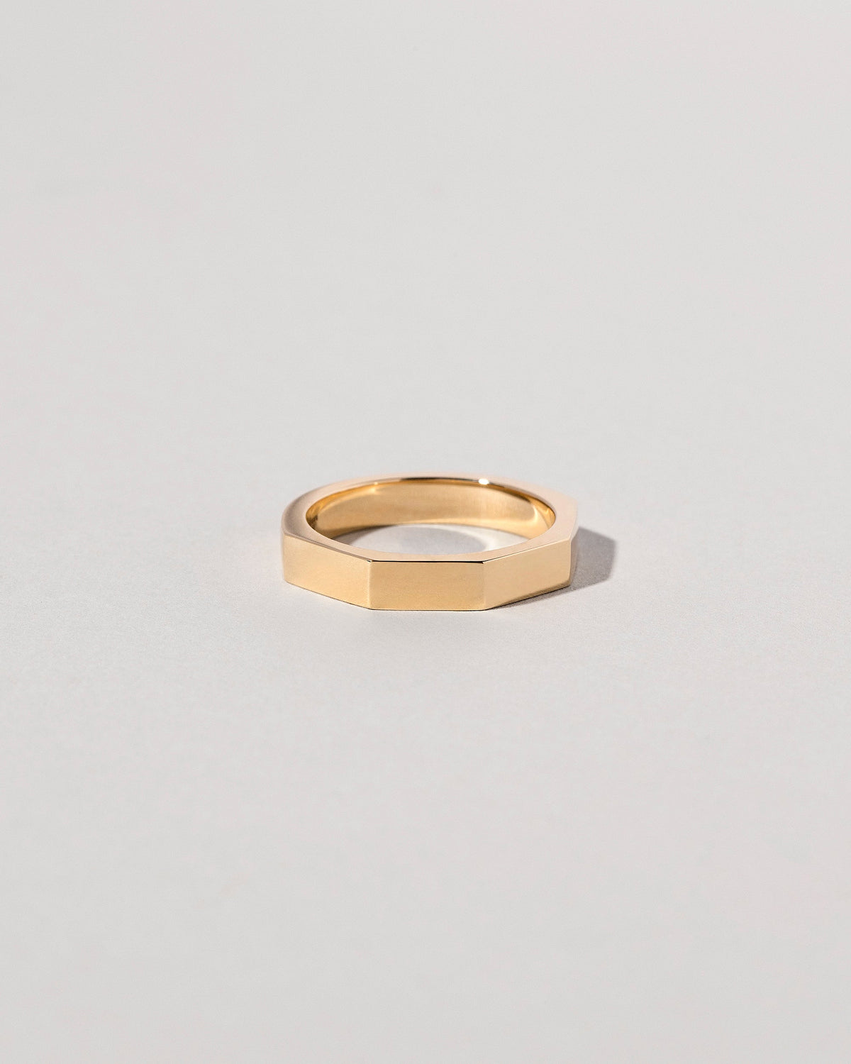 Closeup details of the Gold 4mm Segmented Half Hoop Band on light color background.