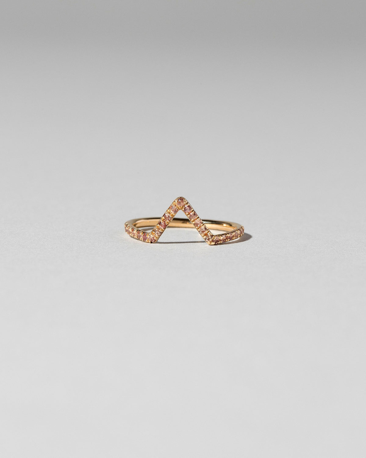 Peach Sapphire Pavé Triangle Band on light color background.