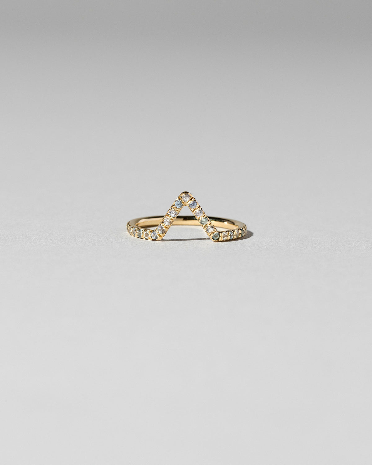Blue Sapphire Pavé Triangle Band on light color background.