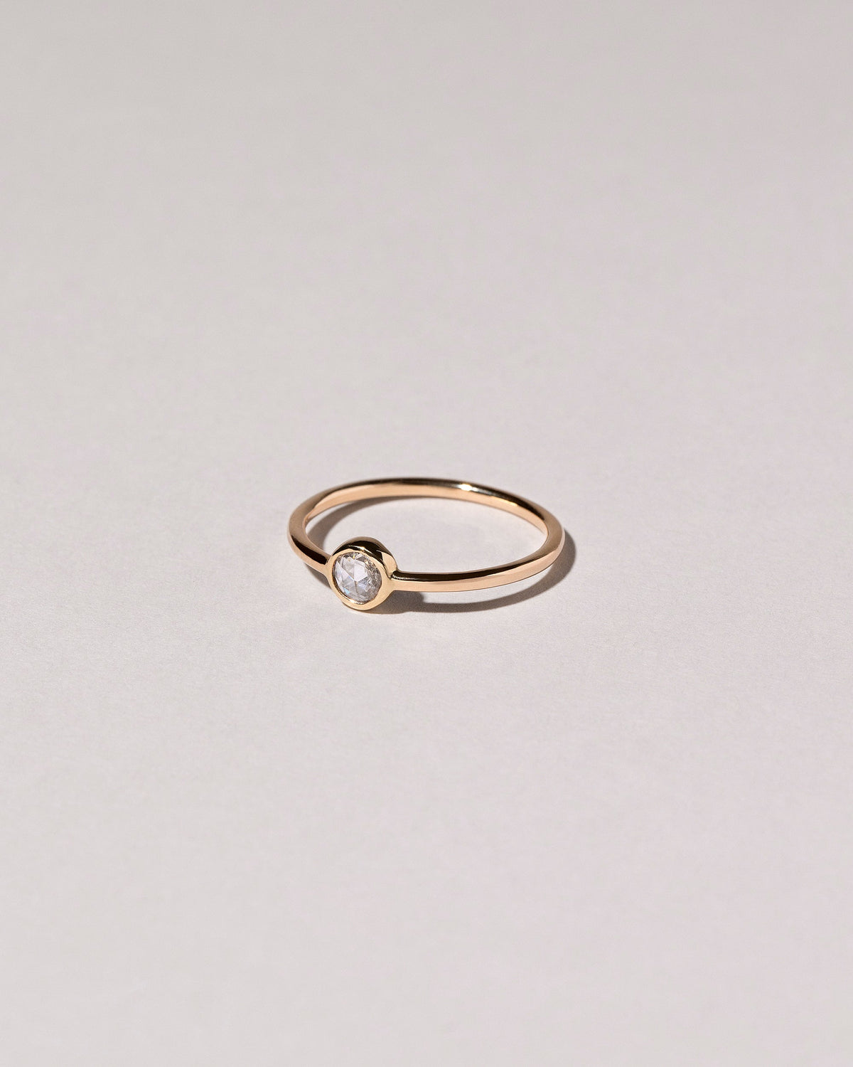 View from the side of the Rose Cut Purple Diamond Ring on light color background.