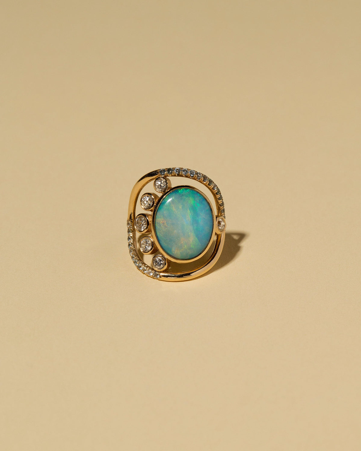 Australian Opal, Diamond & Sapphire Ring on light color background.