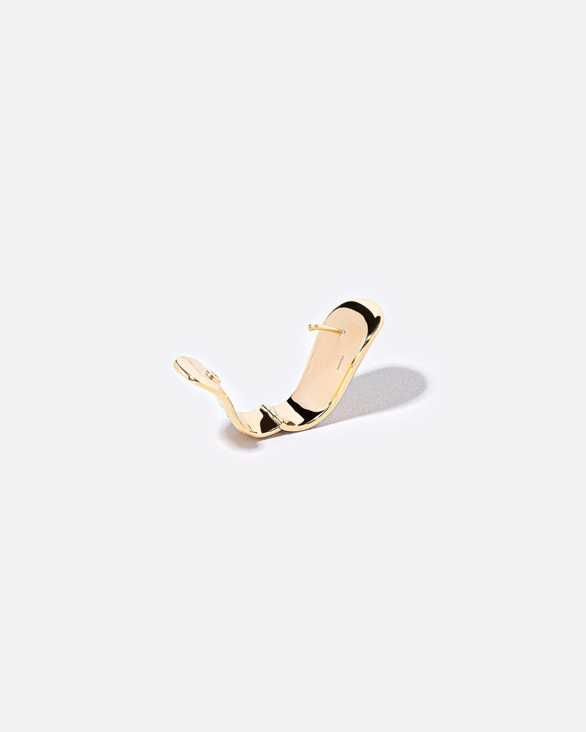 Detail view of the Solid Duality Hoop Earring on light color background.