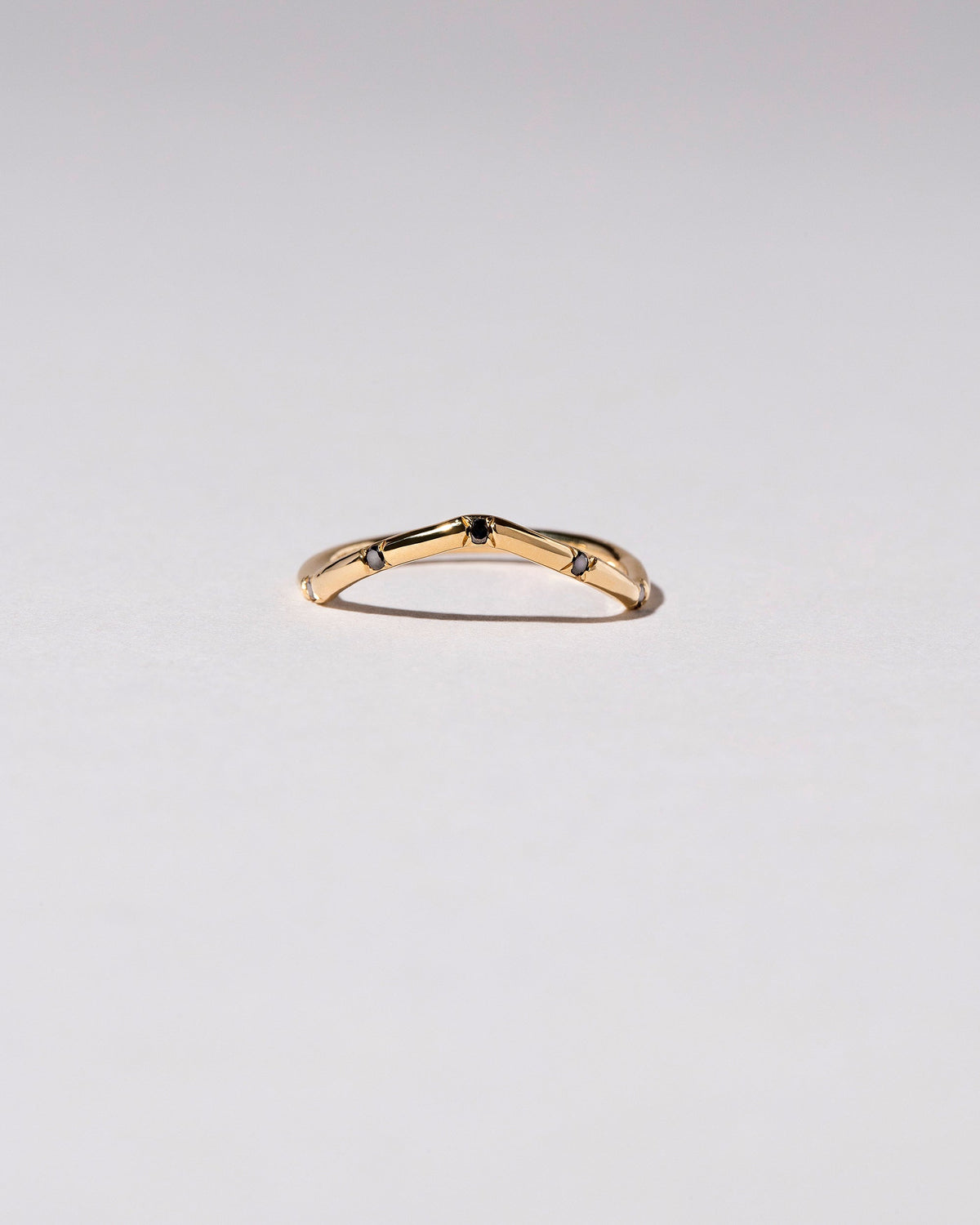 Gold Black Diamond Five Stone Low Peak Band on light color background.