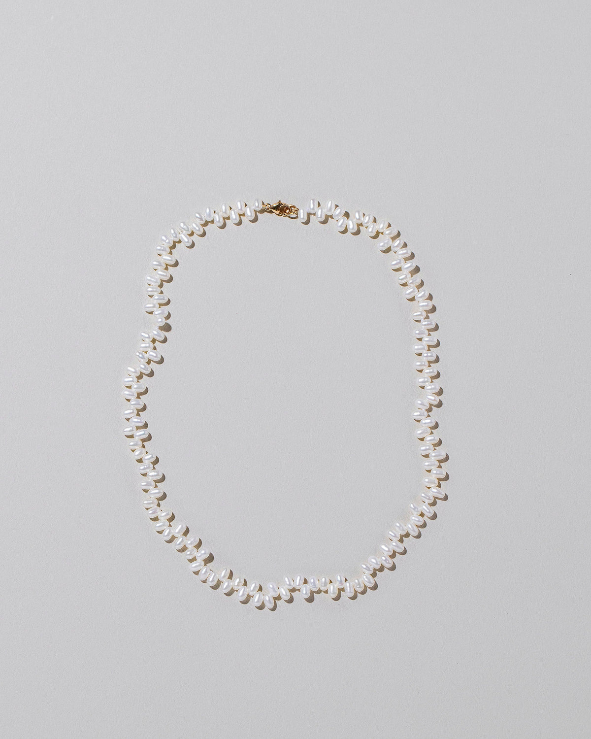Small Zipper Pearl Necklace on light color background.