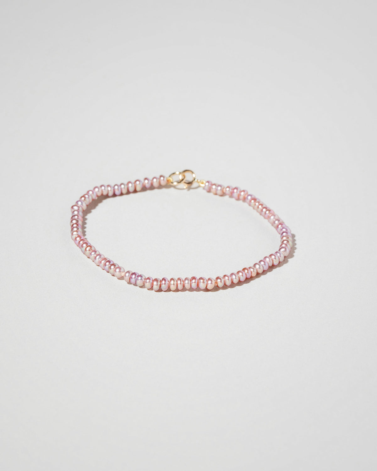 Closeup details of the Pink Lavender Seed Pearl Bracelet on light color background.