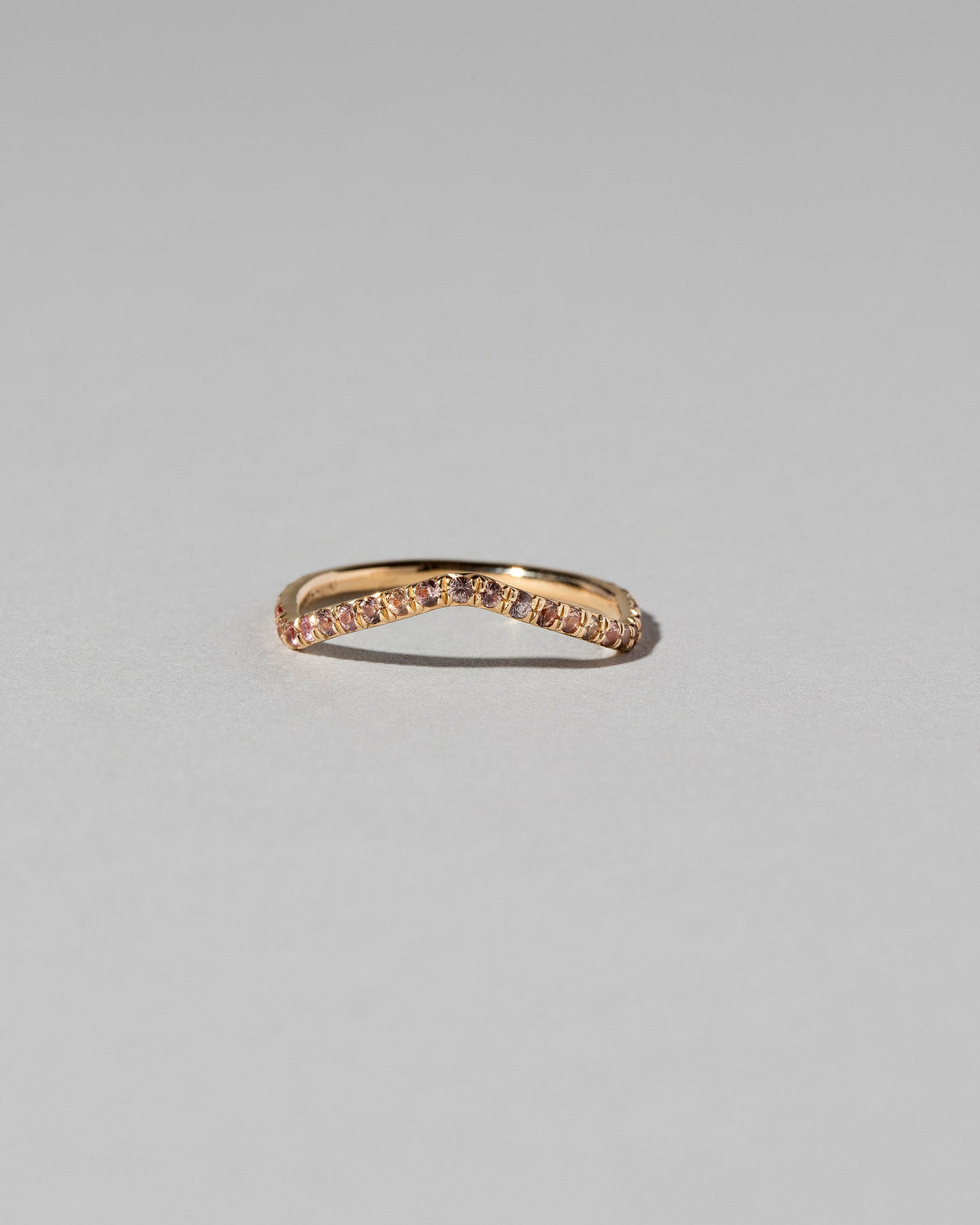 Gold Pavé Peach Sapphire Low Peak Band on light color background.