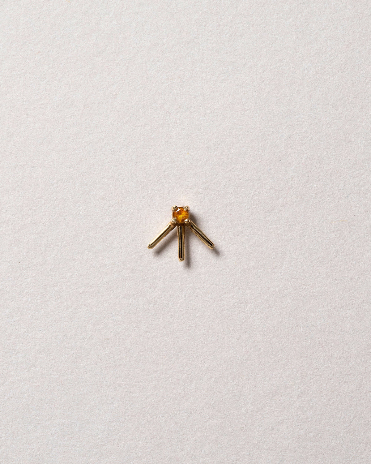 Gold Citrine Sun Ray Stud Earring Single on light color background.