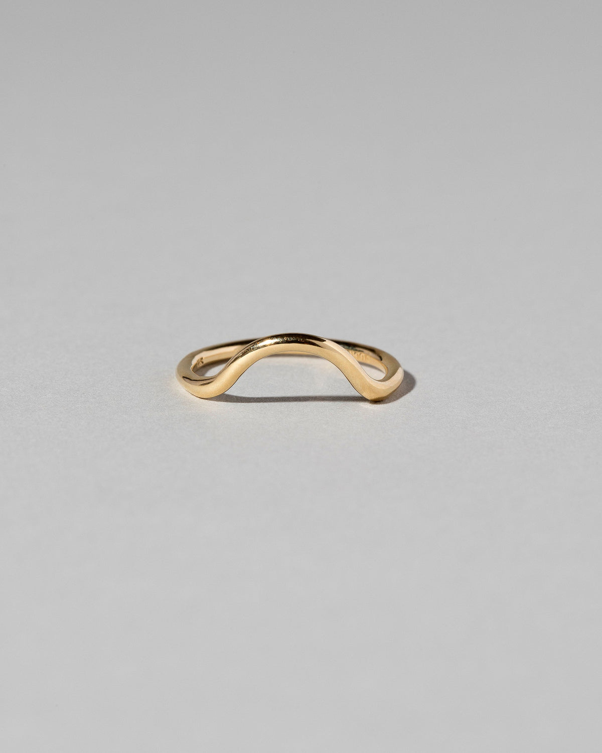 Gold Solid Round Wire Curve Band on light color background.