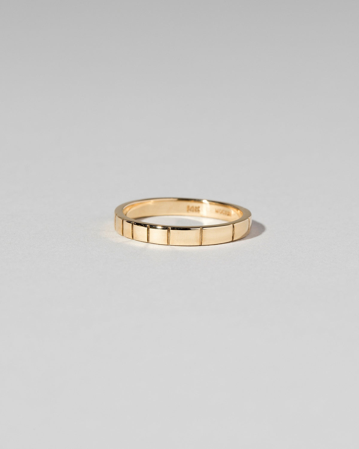 View from the side of the Gold 2mm Etched Lines Bands on light color background.