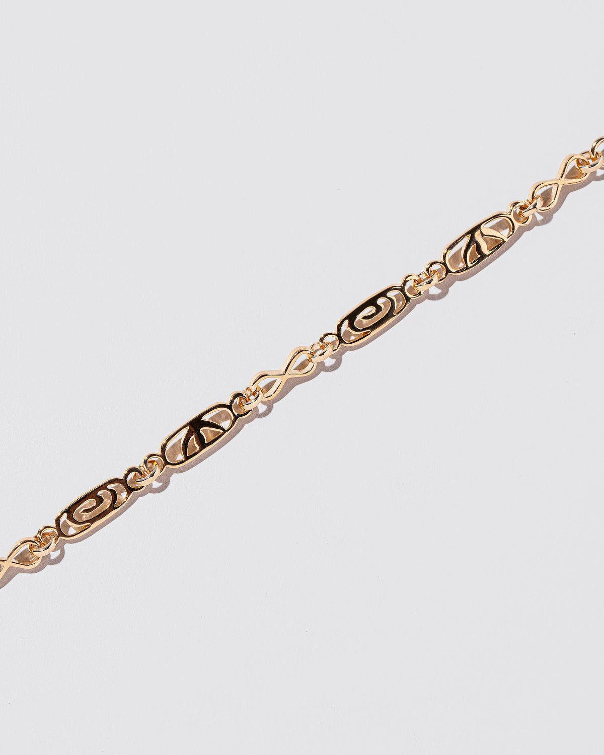 Closeup details of the Infinite Spiral Necklace on light color background.