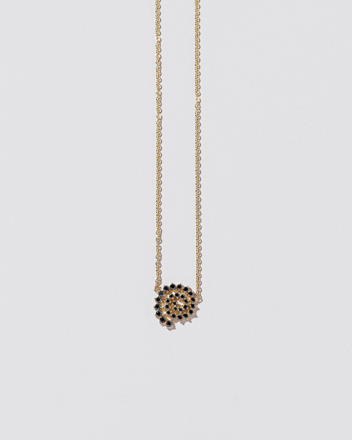 Closeup details of the Full Black Diamond Spiral Necklace on light color background.