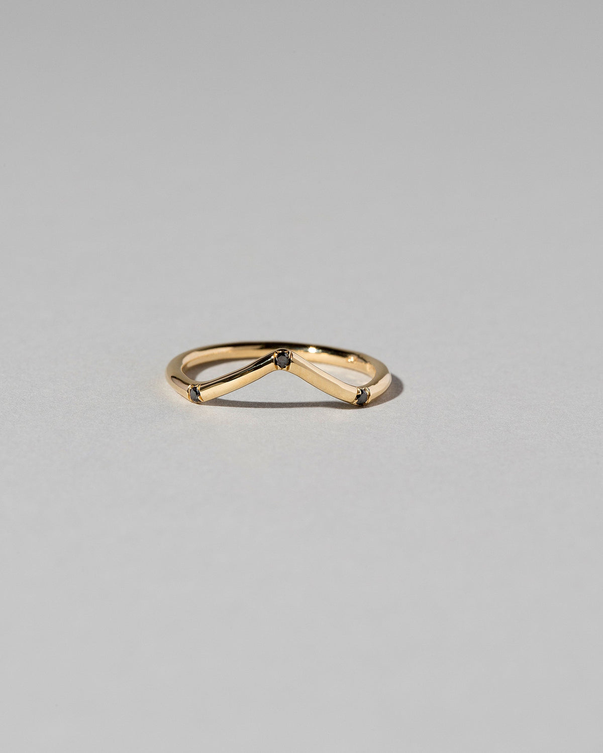 Gold Three Stone Black Diamond High Peak Band on light color background.