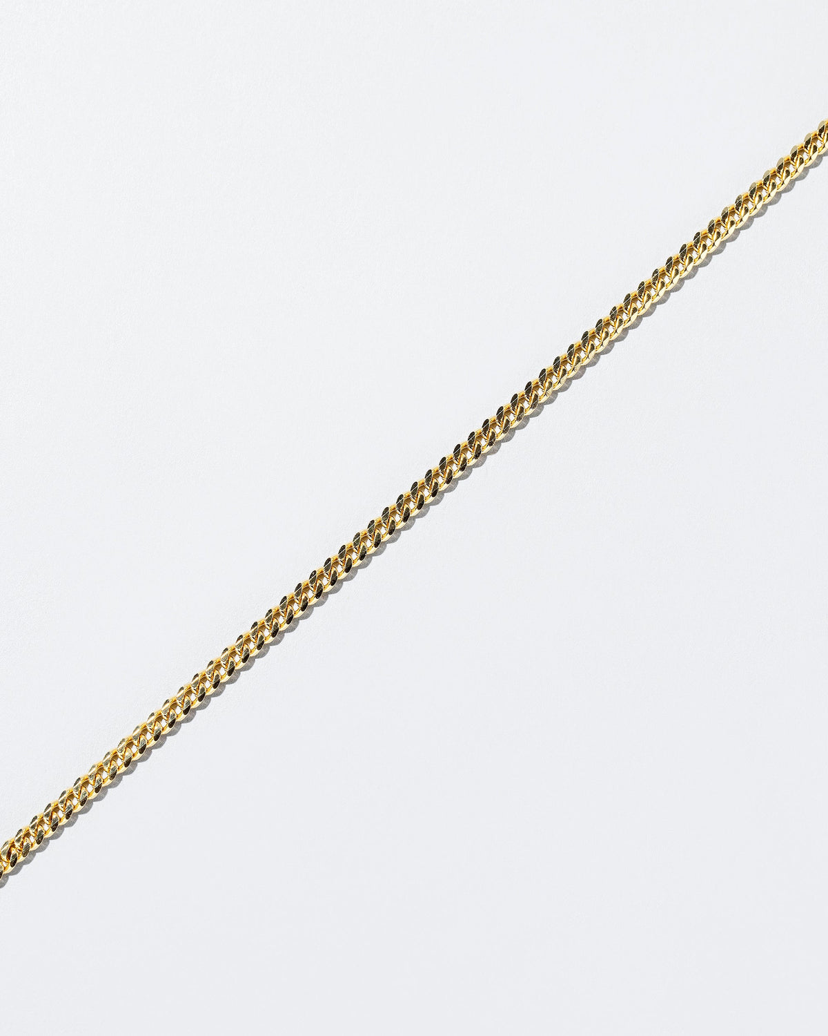 Closeup details of the 2.4mm Curb Chain Necklace on light color background.