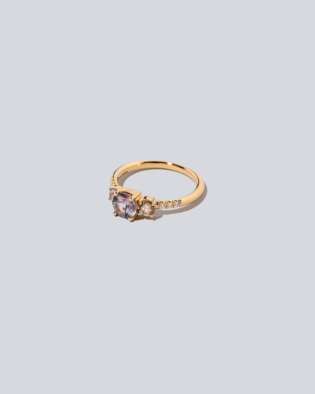 View from the side of the Purple Sapphire & Champagne Diamond Orion Ring on light color background.