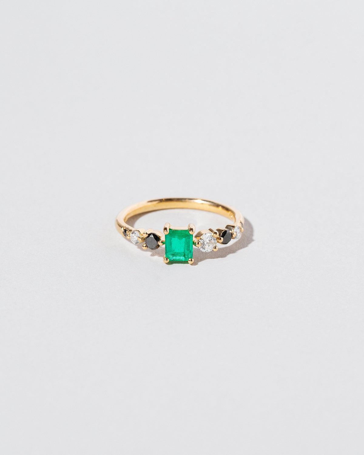 Emerald Seven Sisters Ring on light color background.