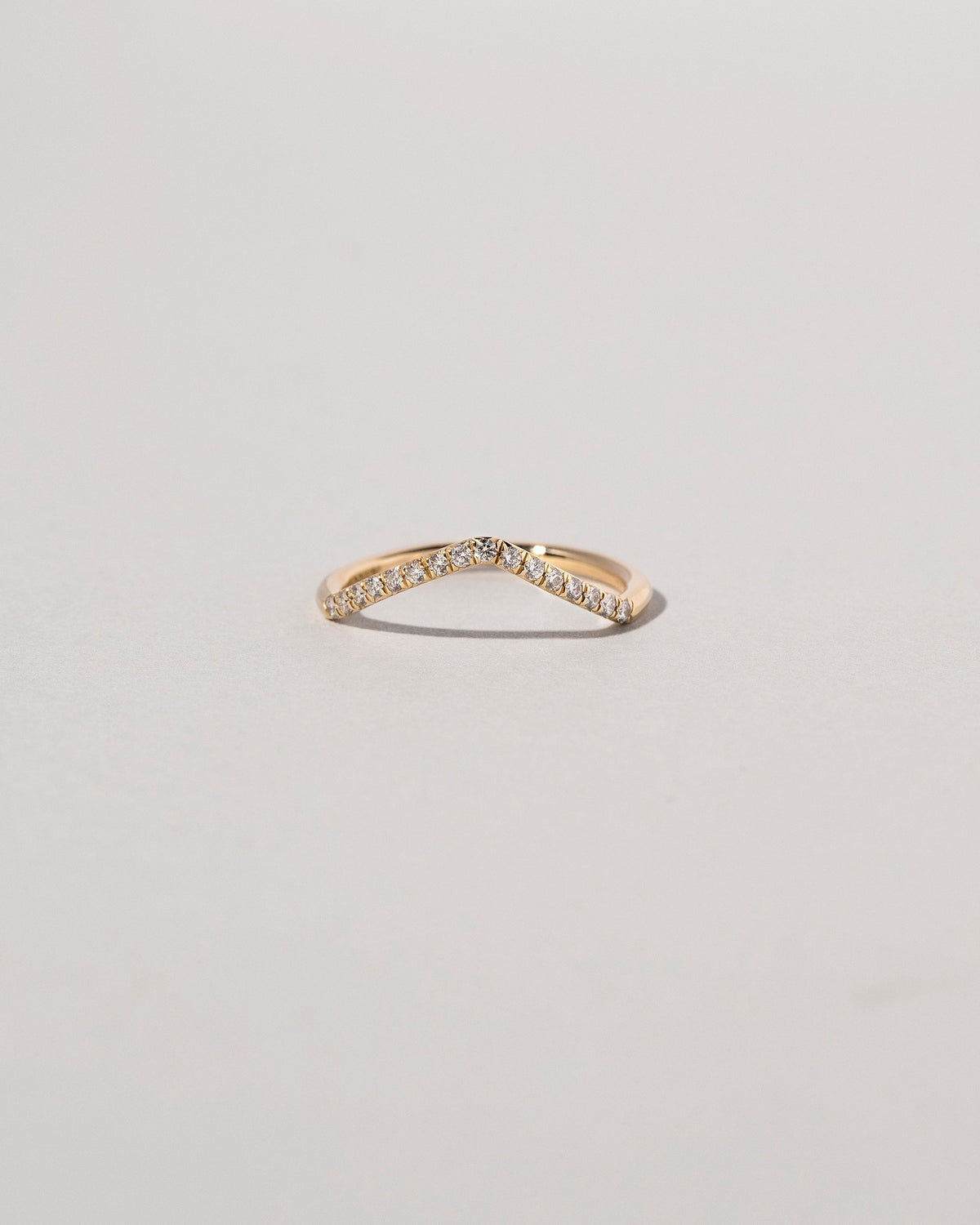 Gold Pavé White Diamond Low Peak Band on light color background.