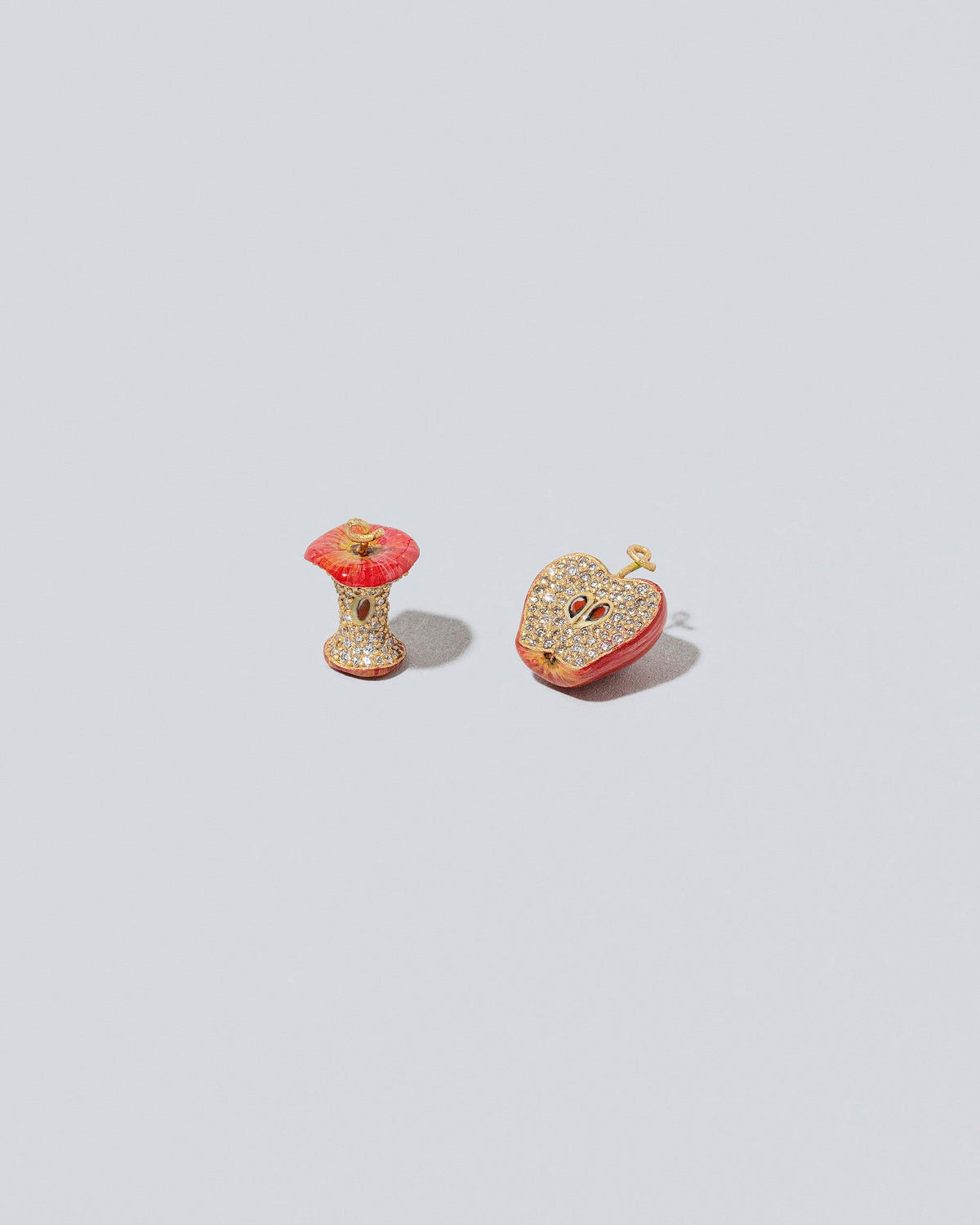 Closeup details of the Red Apple Core Charm on light color background.