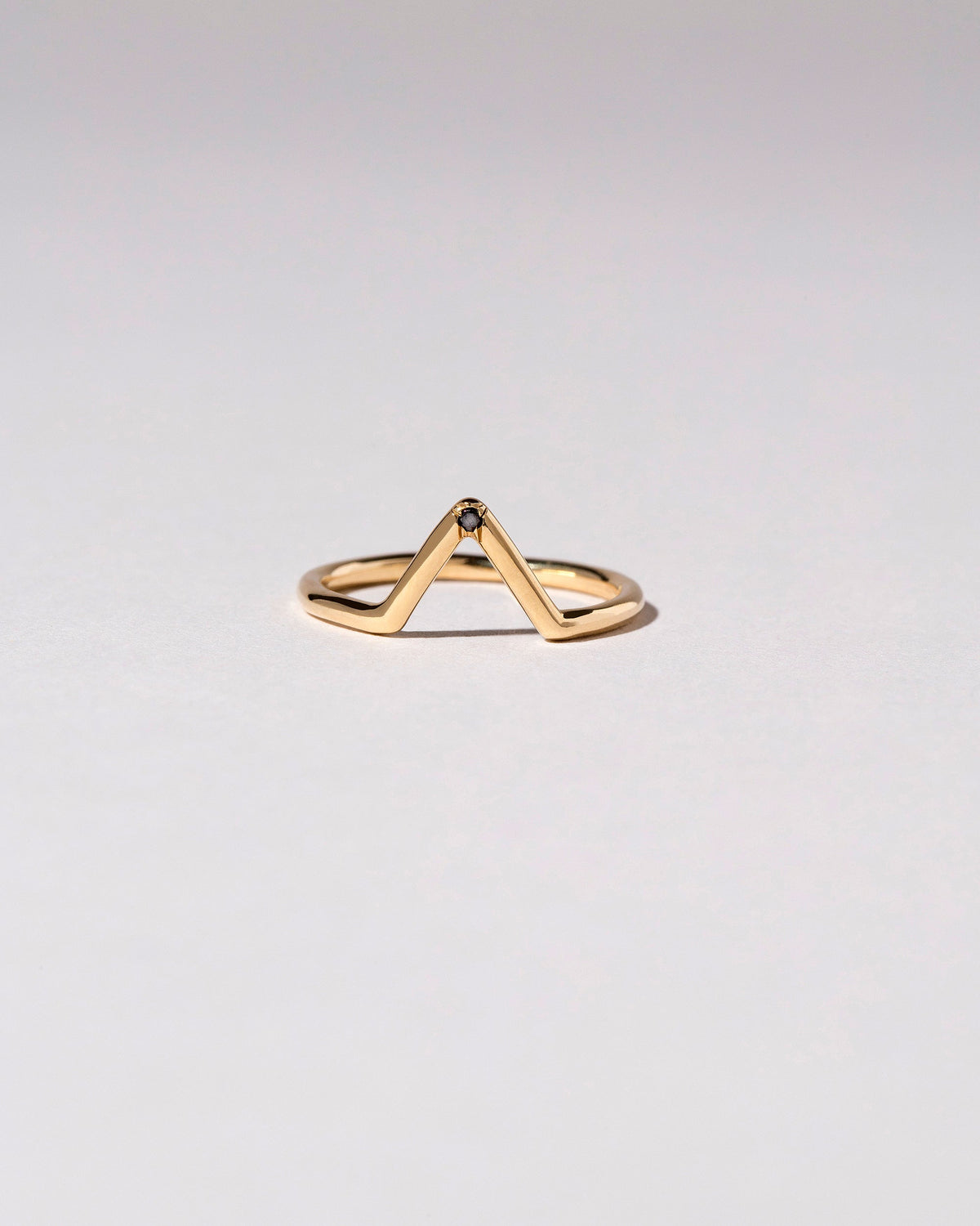 Gold Single Burnish-Set Black Diamond Triangle Band on light color background.