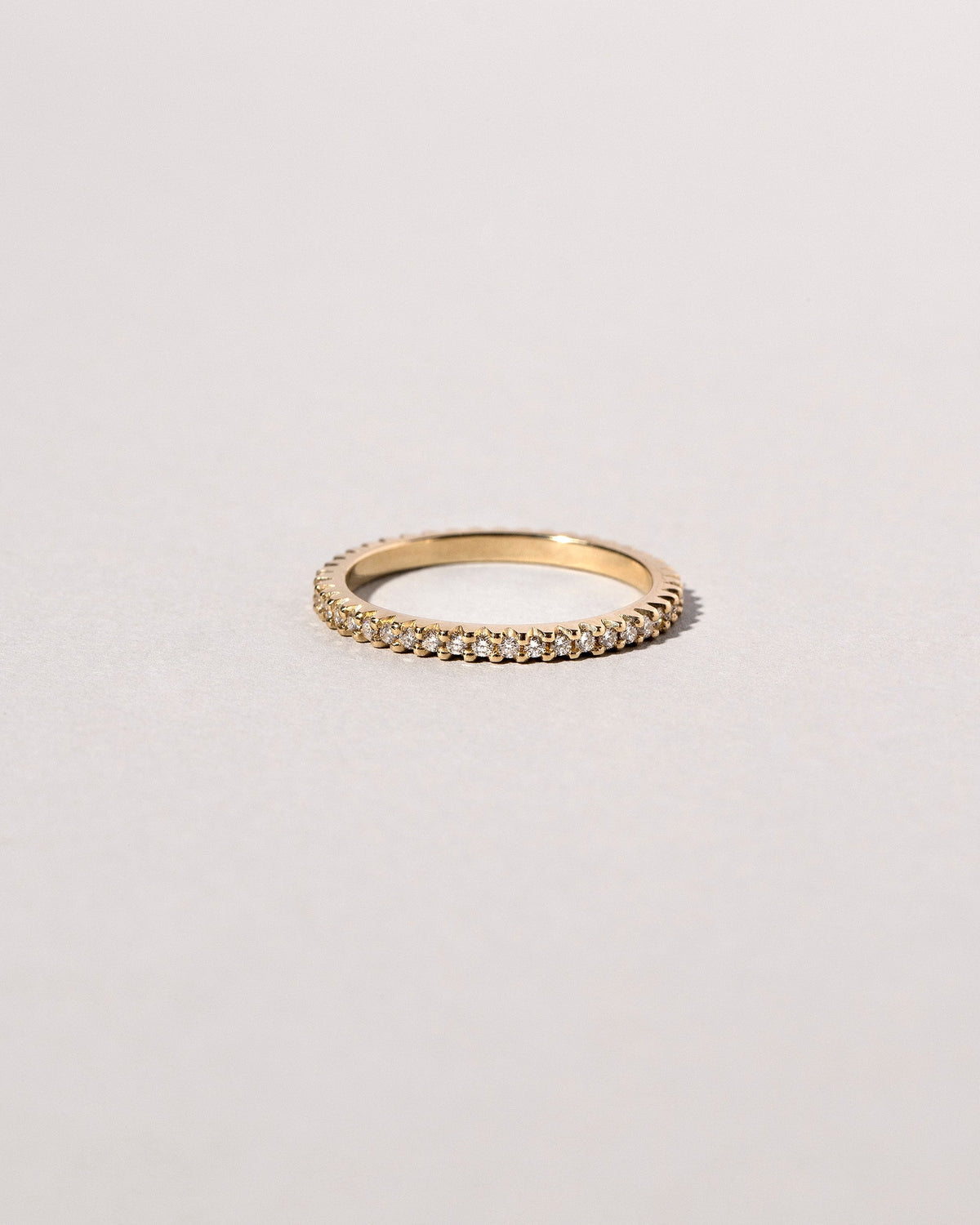Closeup details of the Gold White Diamond Gear Edge Band on light color background.