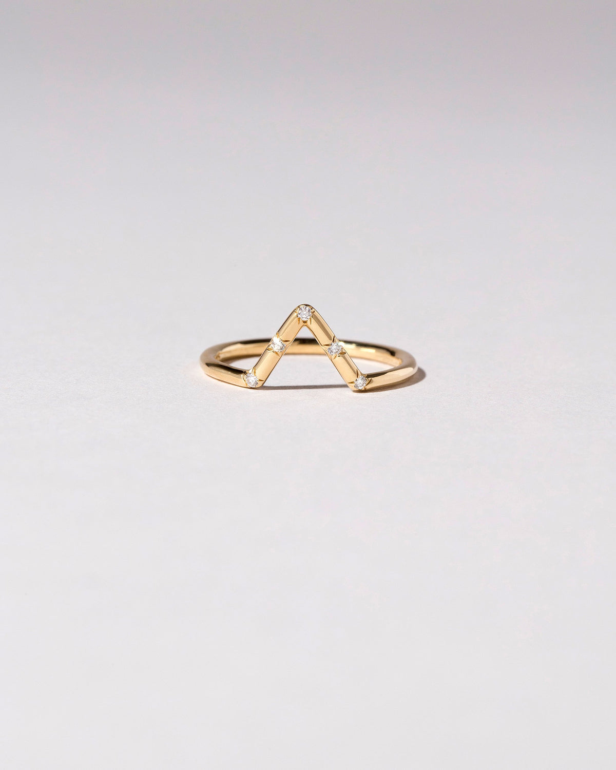 Gold White Diamond Five Stone Triangle Band on light color background.