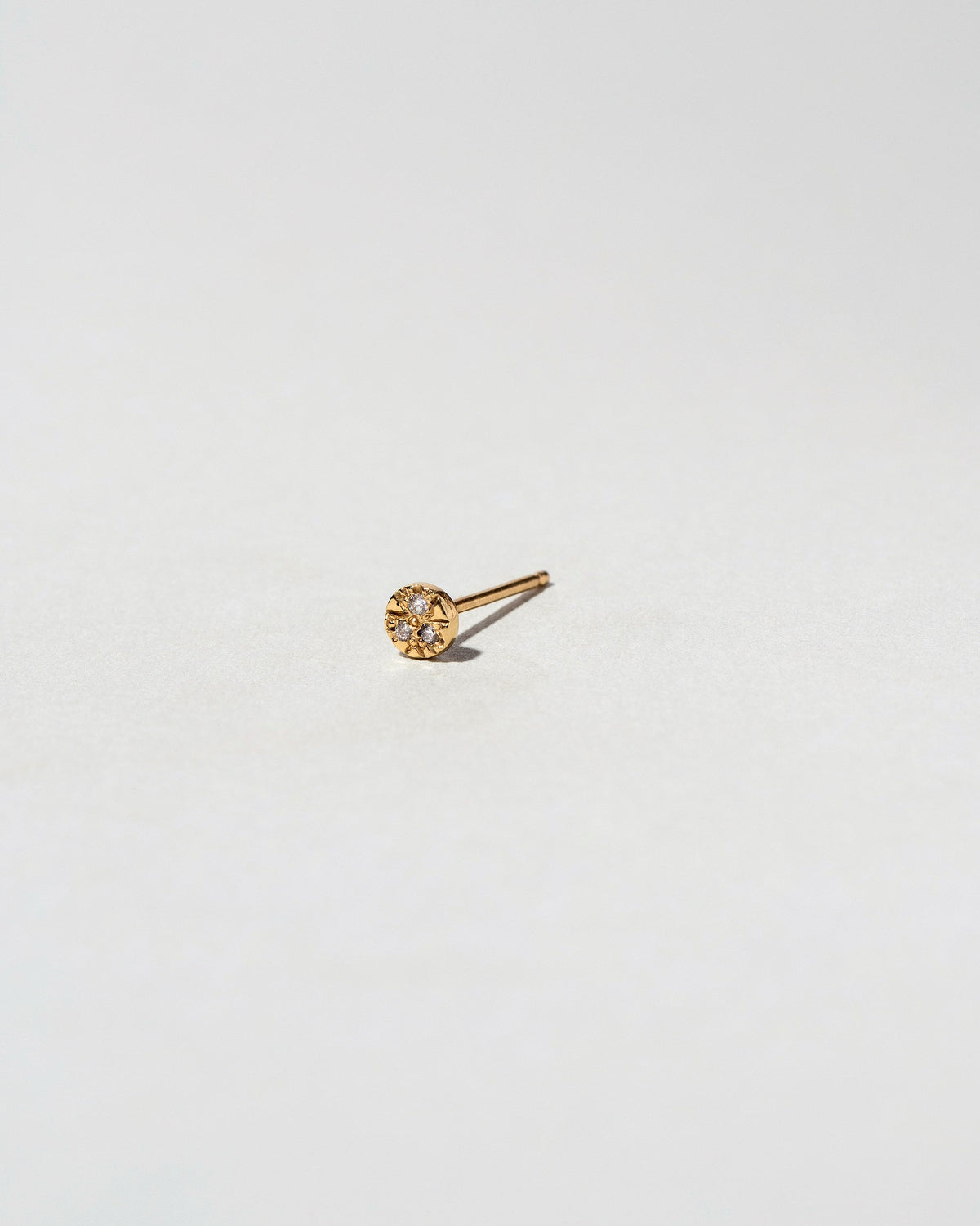 Gold White Diamond Circle Stud Earring Single on light color background.