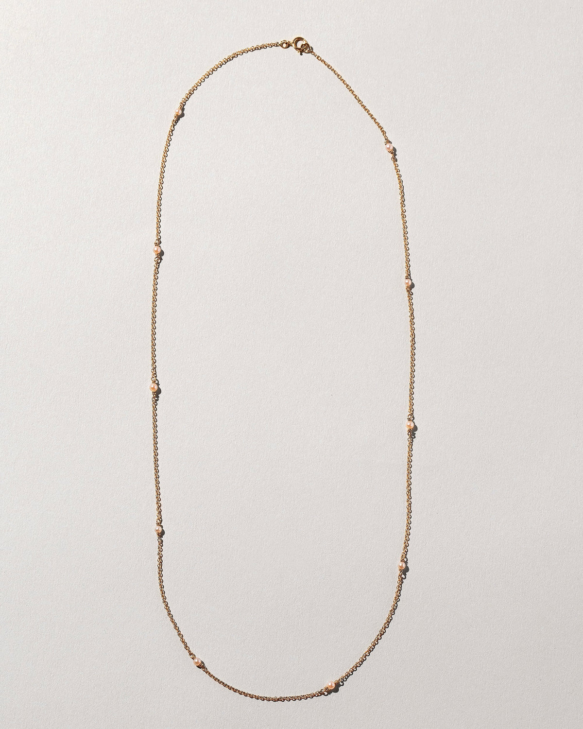  Natural Pink Seed Pearl Necklace on light color background.