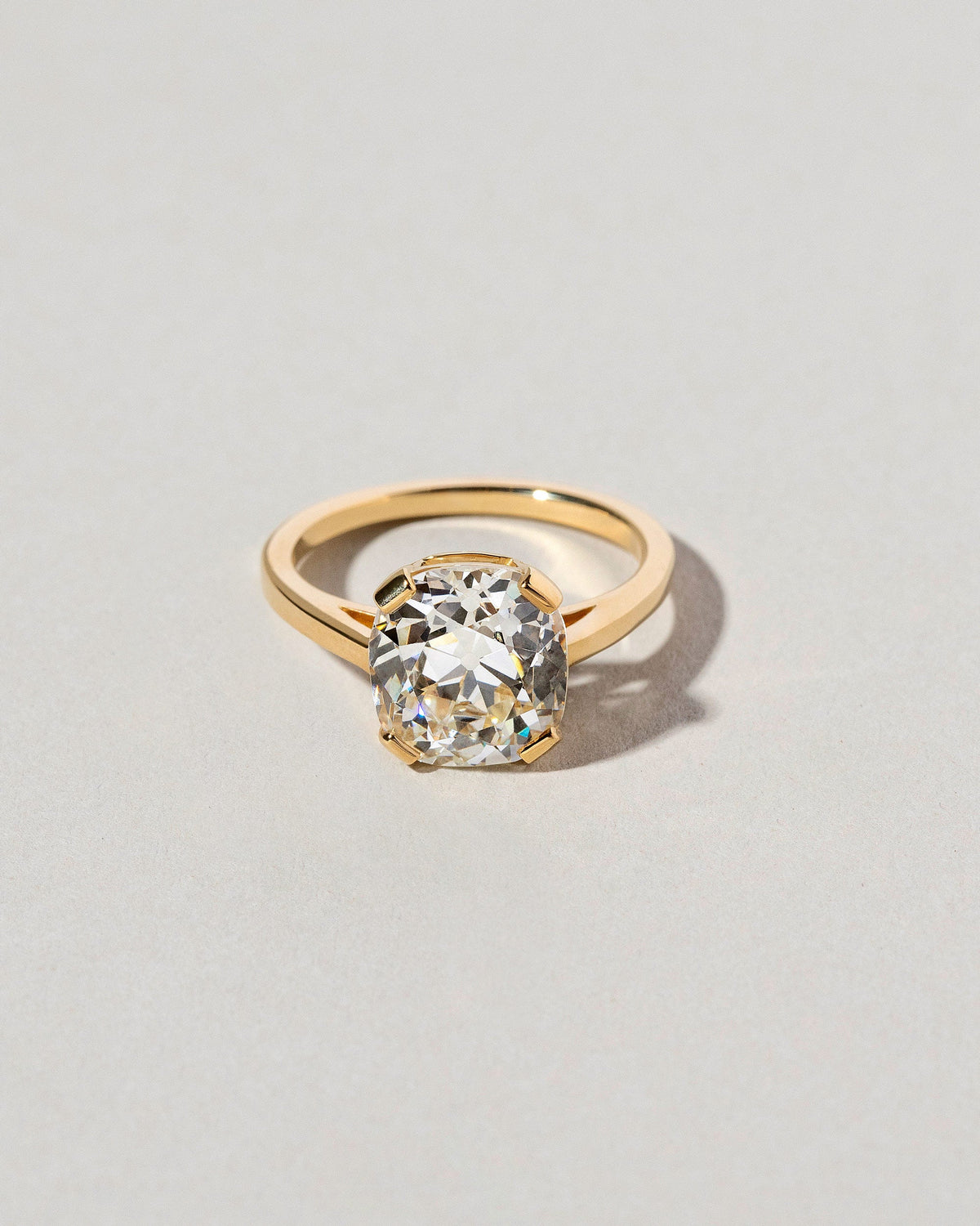 Cushion Cut Diamond Solitaire Ring on light color background.