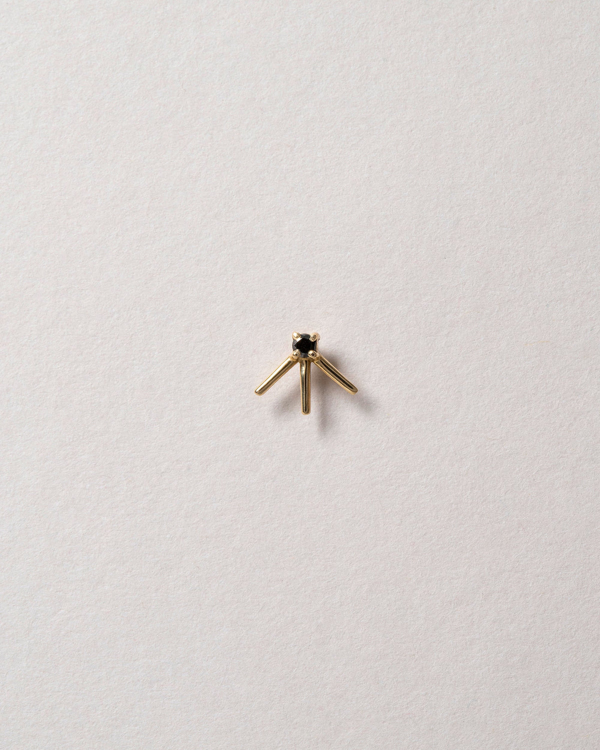 Gold Black Diamond Stud Earring Single on light color background.