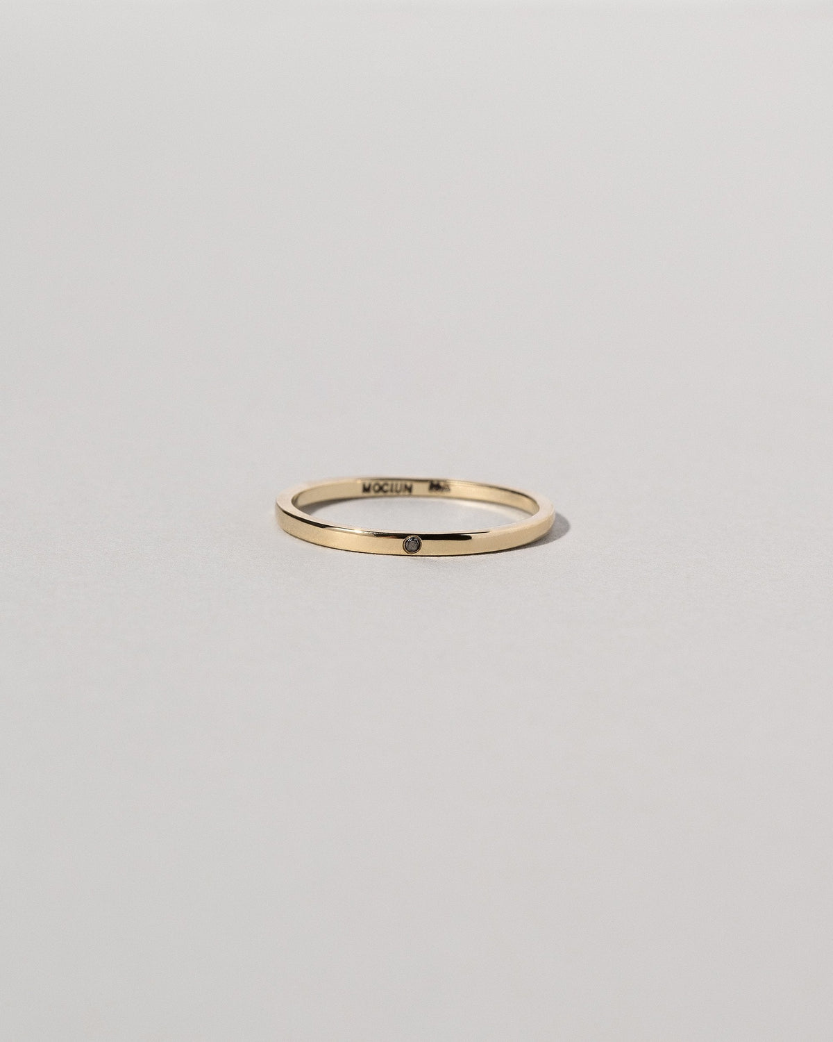 Gold 1.5mm Square Wire Band with Single Stone Black Diamond 1.3mm on light color background.