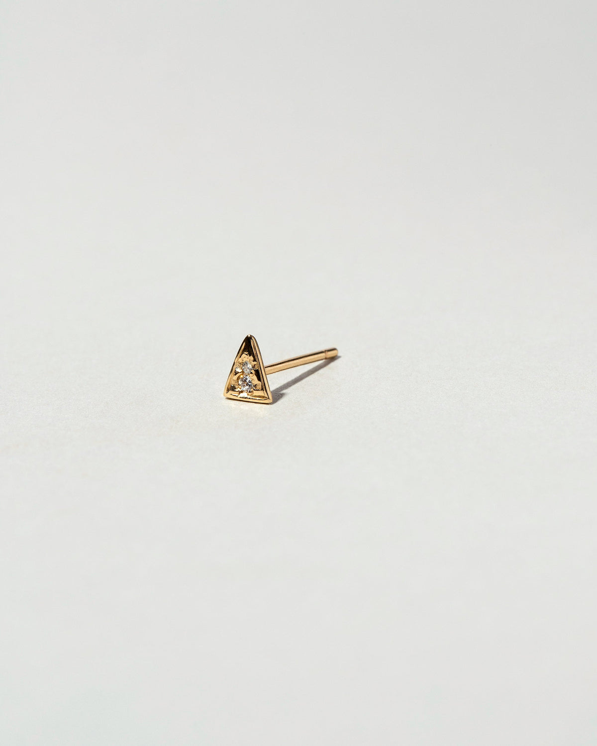 Gold White Diamond Triangle Stud Earring Single on light color background.