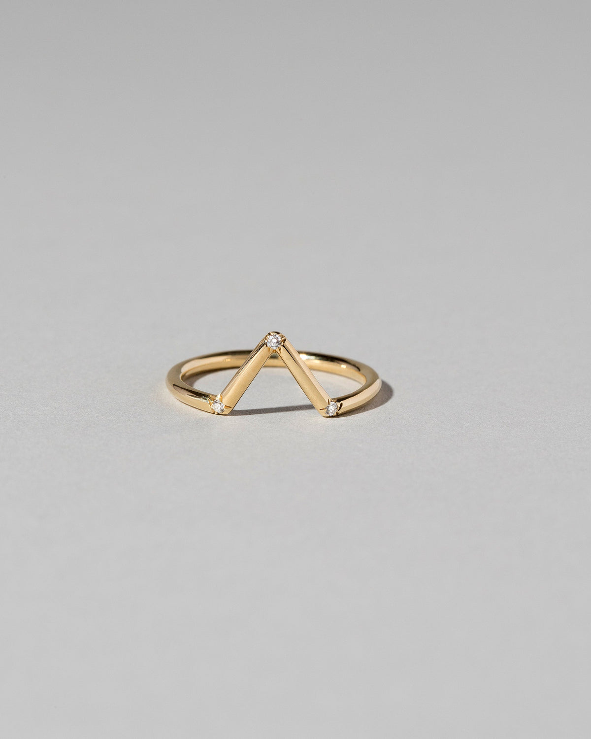 Gold White Diamond Three Stone Triangle Band on light color background.