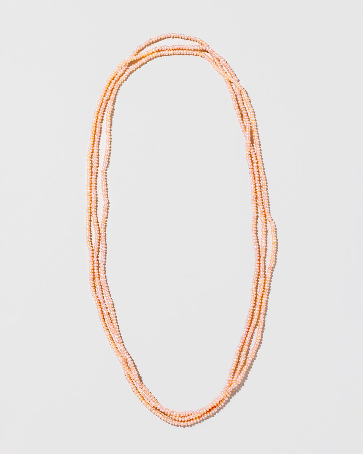 Pink Peony Seed Pearl Rope Necklace on light color background.