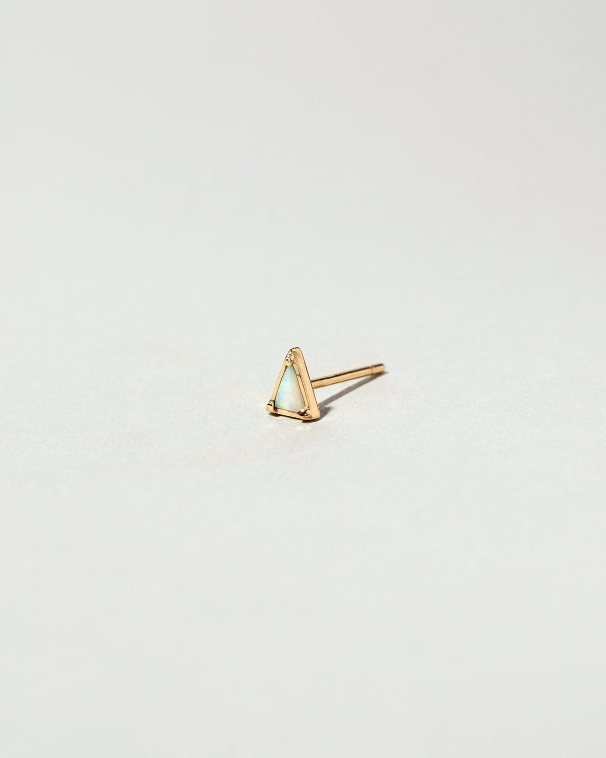 Gold White Opal Triangle Stud Earring Single on light color background.
