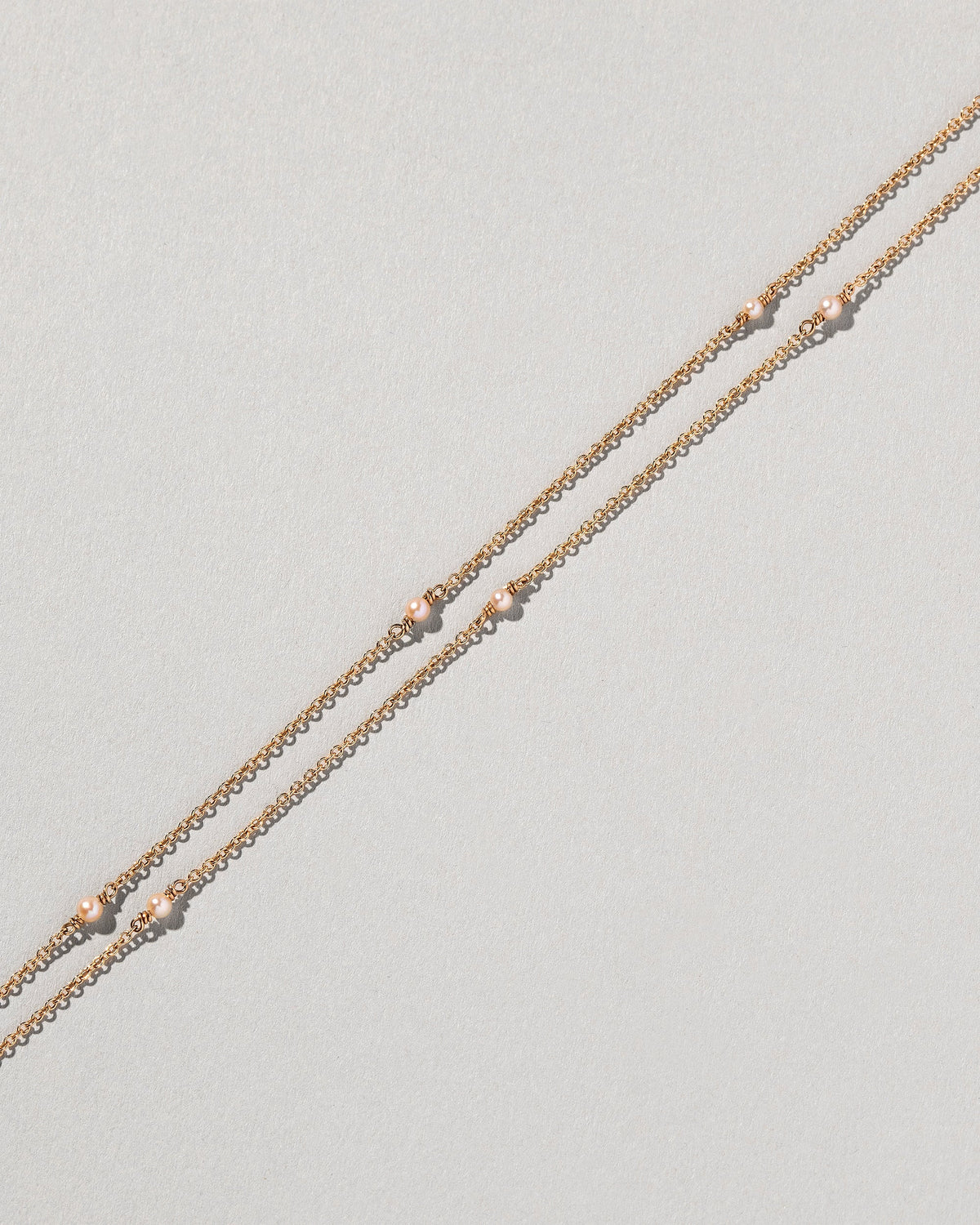  Natural Pink Seed Pearl Necklace on light color background.