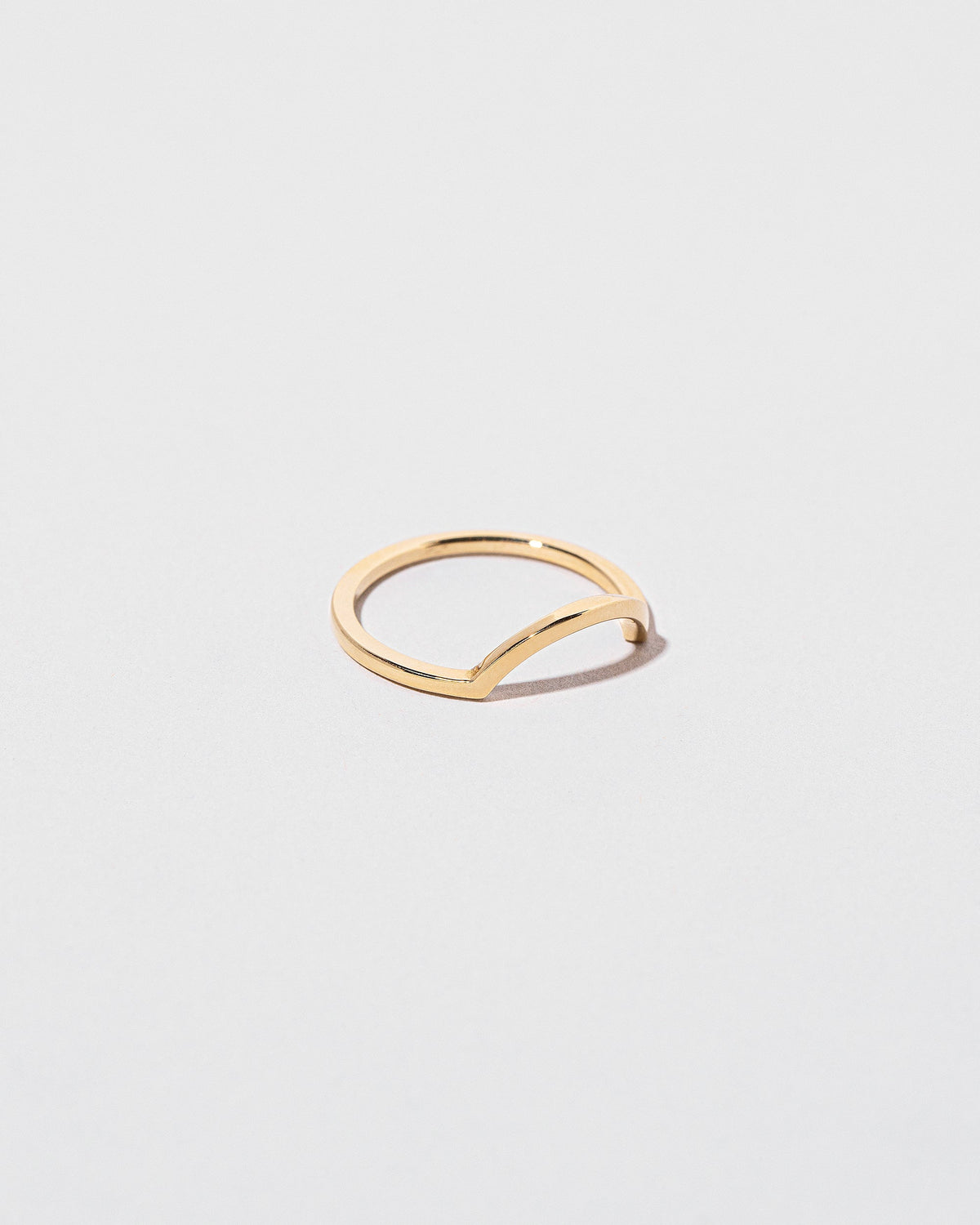 View from the side of the Gold Square Wire Curve Band on light color background.