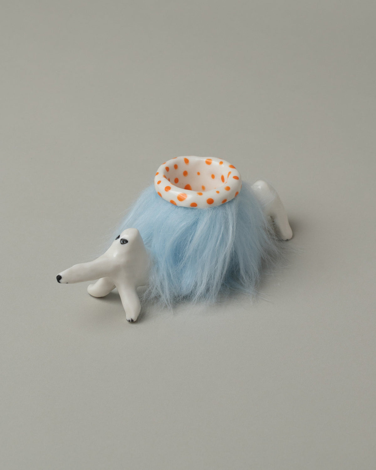 Closeup detail of the Eleonor Boström Orange Furry Baggage Dog on light color background.