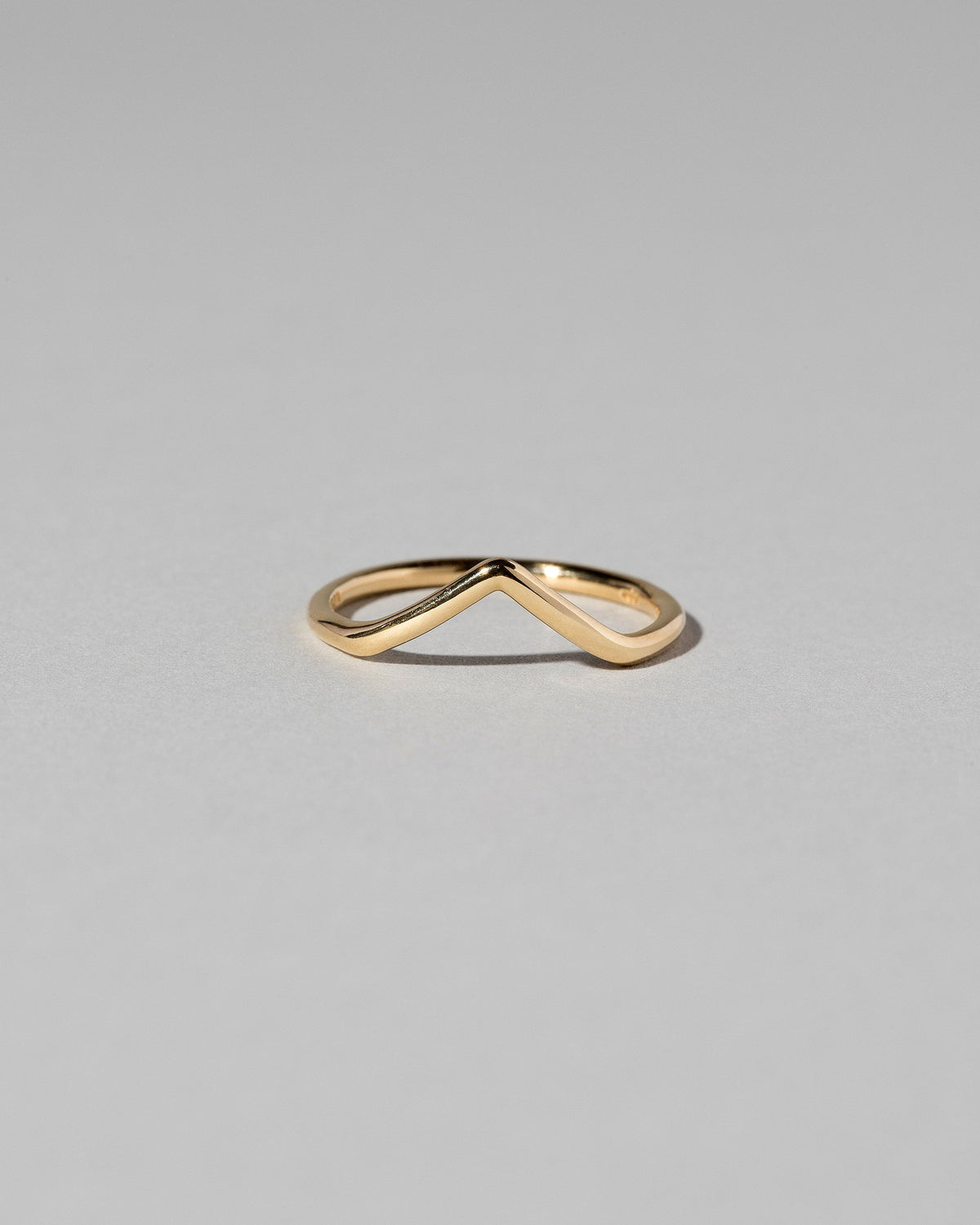 Gold Solid Round Wire High Peak Band on light color background.