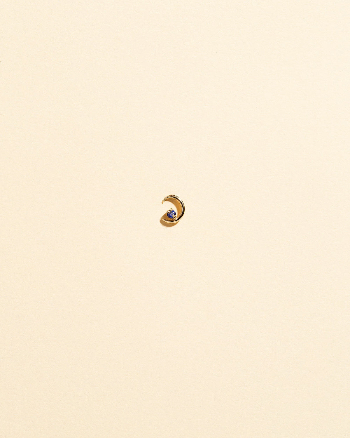 Left Sapphire Moon Ray Stud Earring Single on light color background.