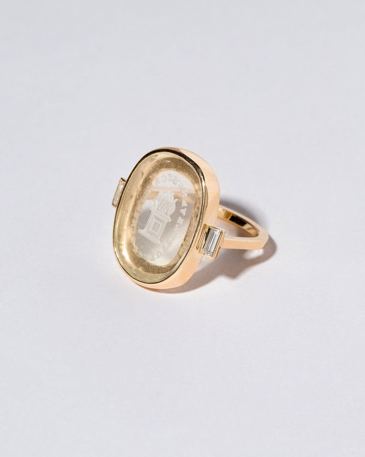 View from the side of the Passion Intaglio Seal Ring on light color background.