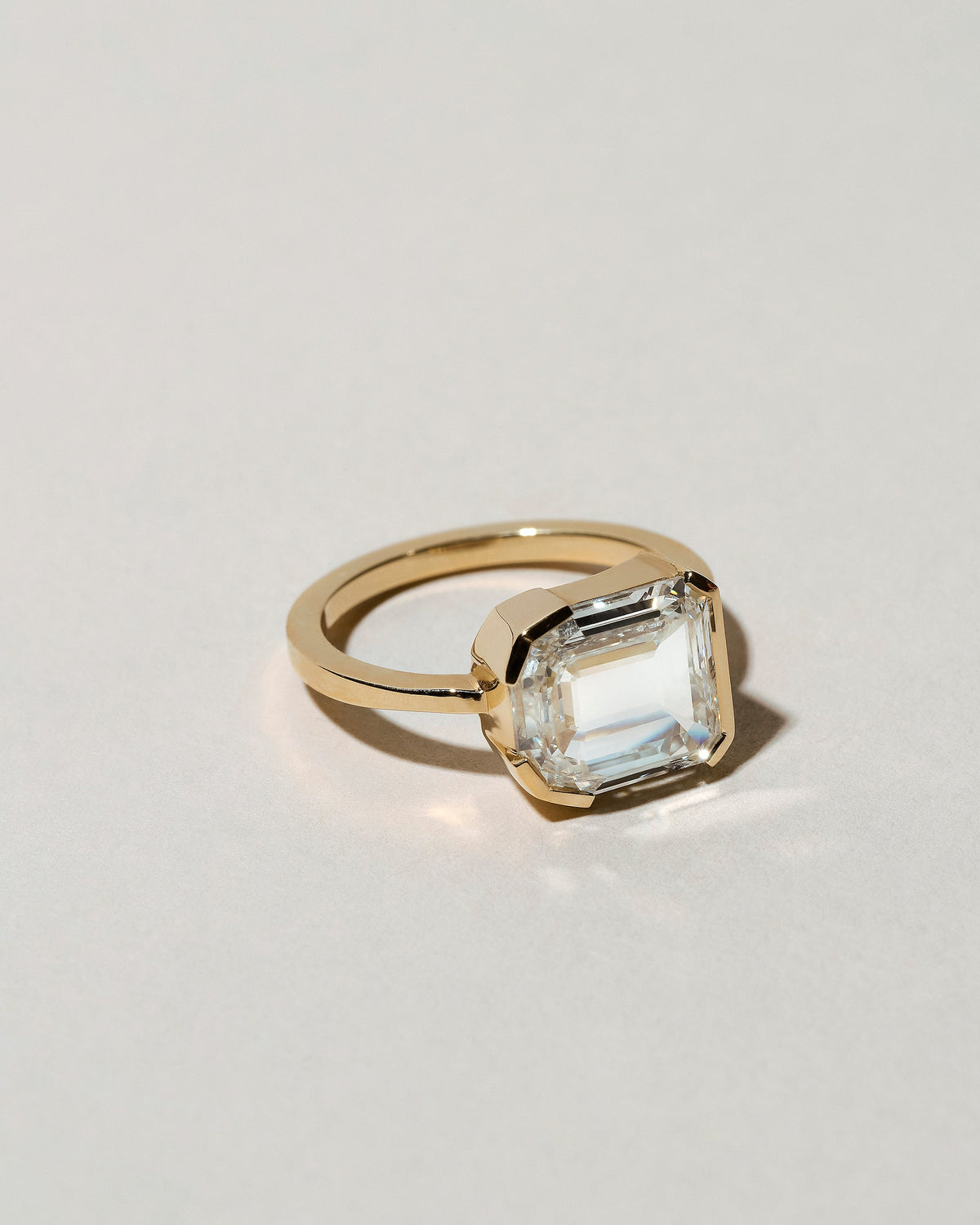 View from the side of the Shield Step Cut Diamond Ring on light color background.