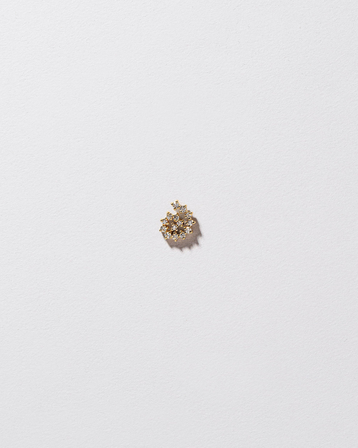Mini White Diamond Left Spiral Stud Earring Single on light color background.
