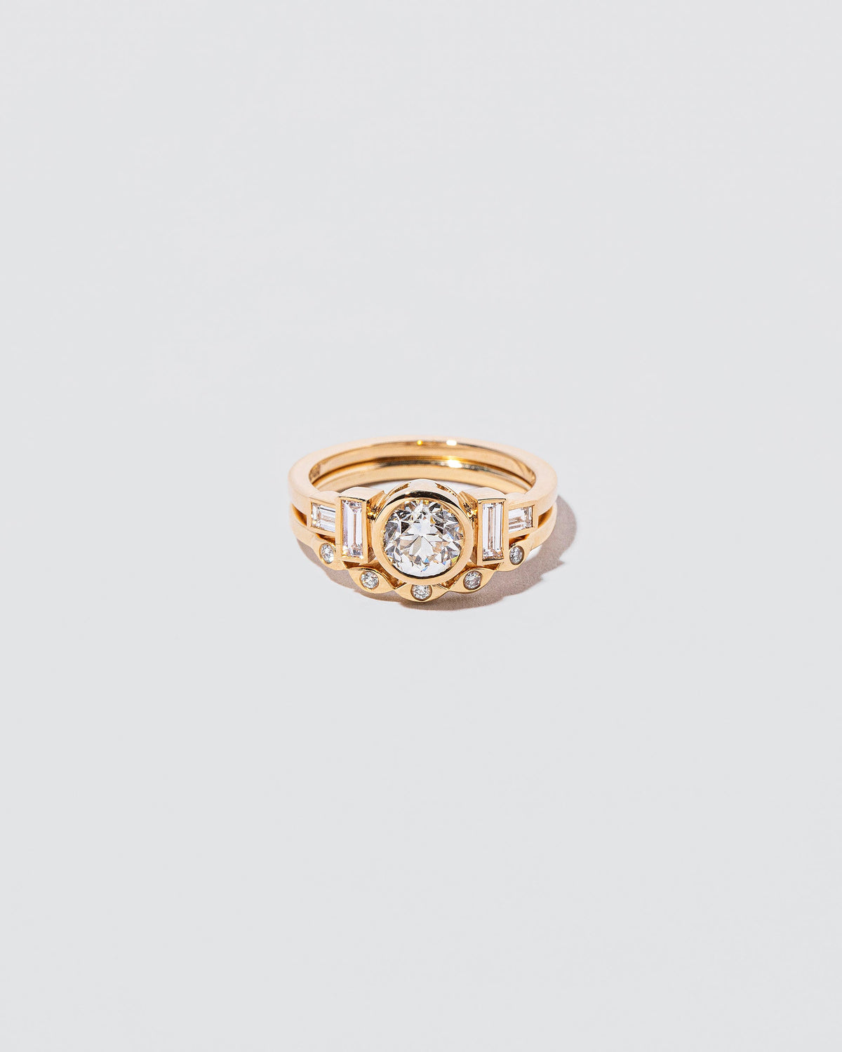 Gold Seeing Eye Band and Diamond Third Eye Ring on light color background.