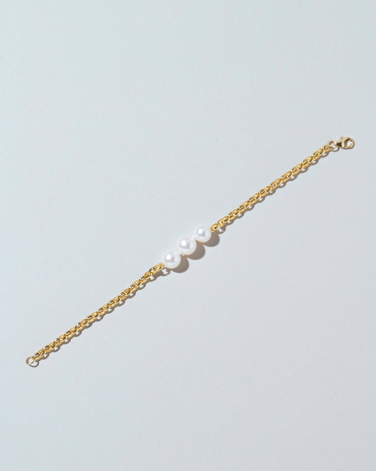 Three Pearl Station Bracelet Short Loop Chain on lightcolor background.