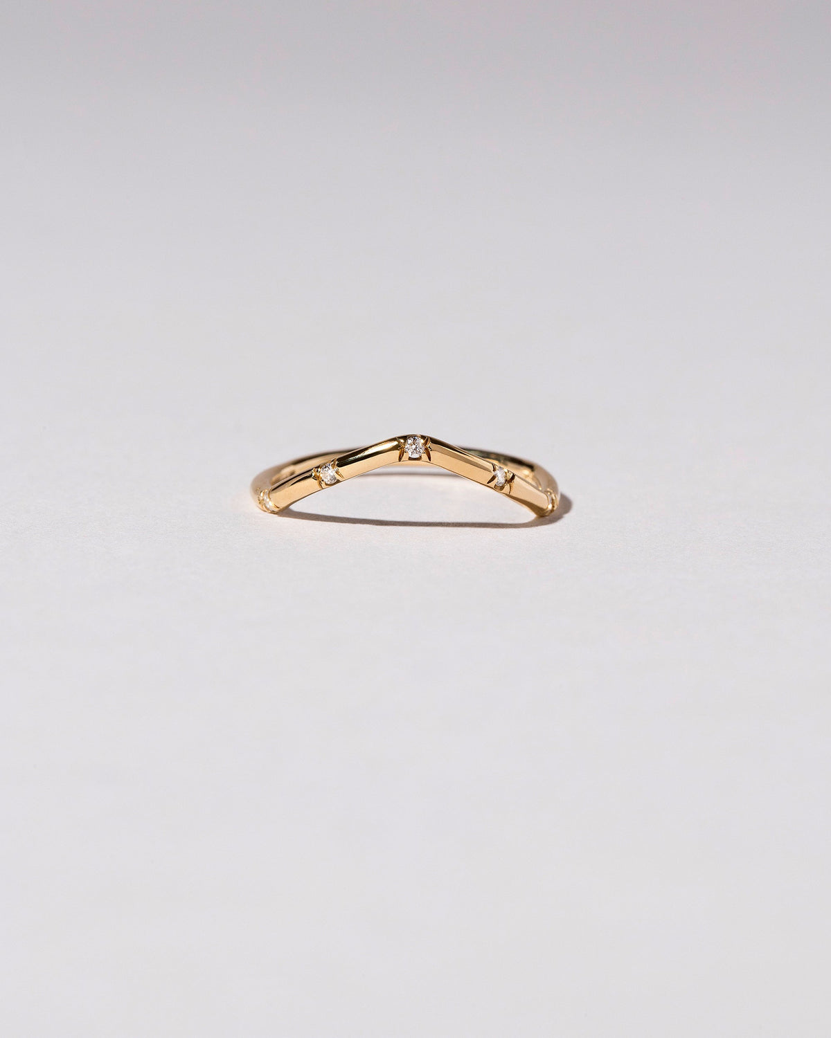 Gold White Diamond Five Stone Low Peak Band on light color background.