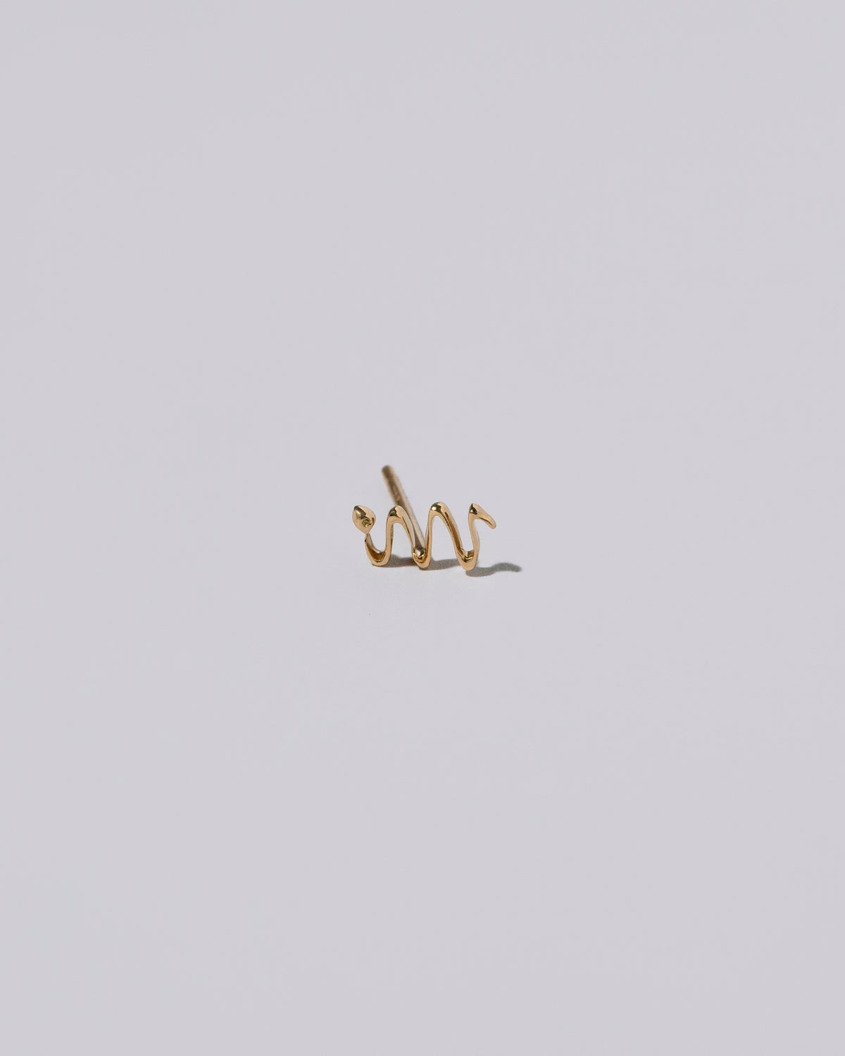 Left Snake Stud Earring Single on light color background.
