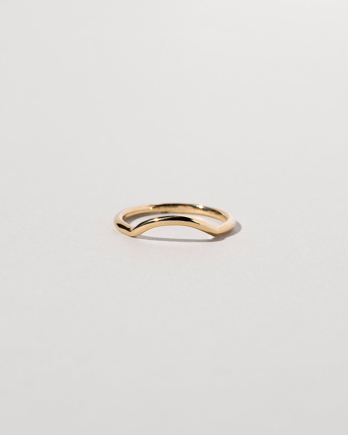 Gold Solid Round Wire Mini Curve Band on light color background.