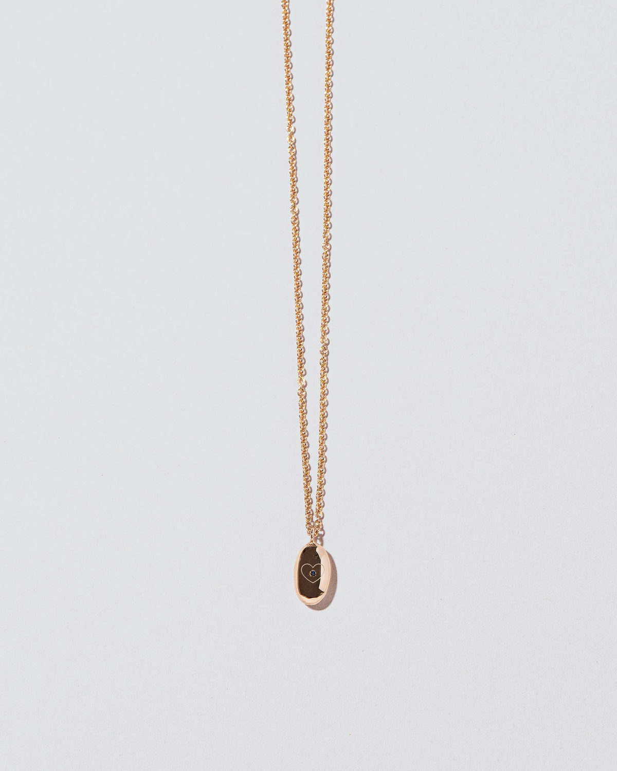 Closeup detail of Bead Time Capsule Necklace with Gemstone and Engraving added on light color background.