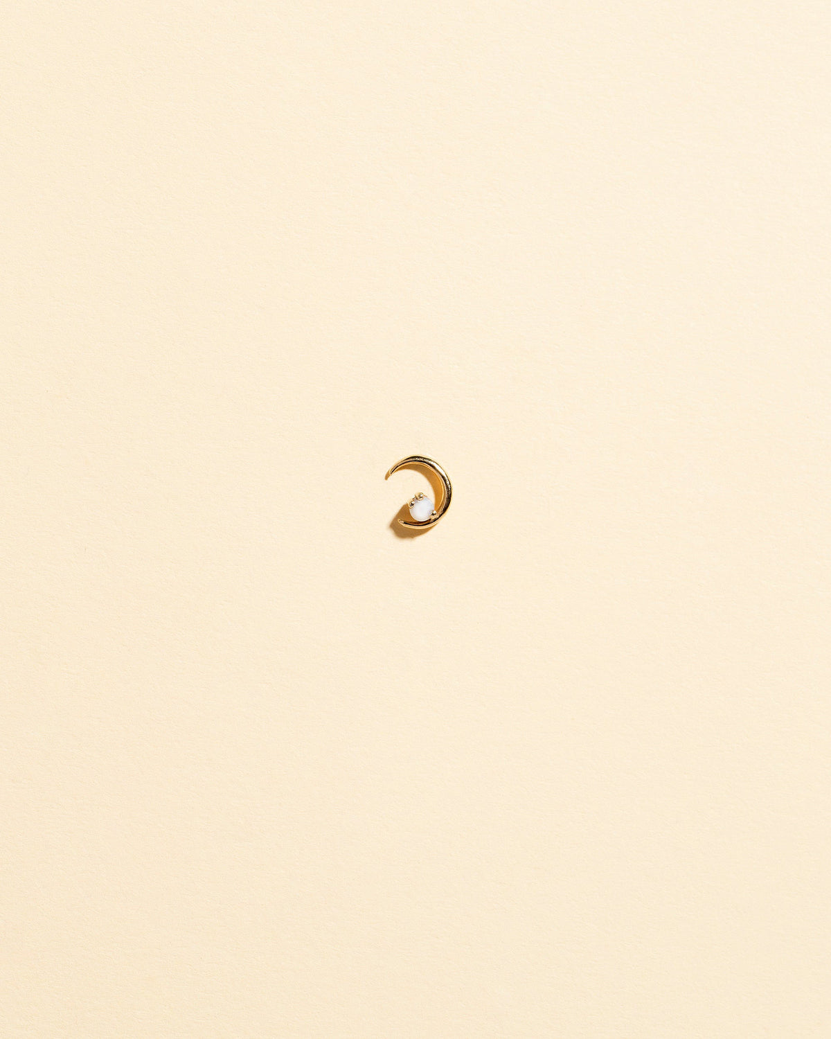 Left Opal Moon Ray Stud Earring Single on light color background.