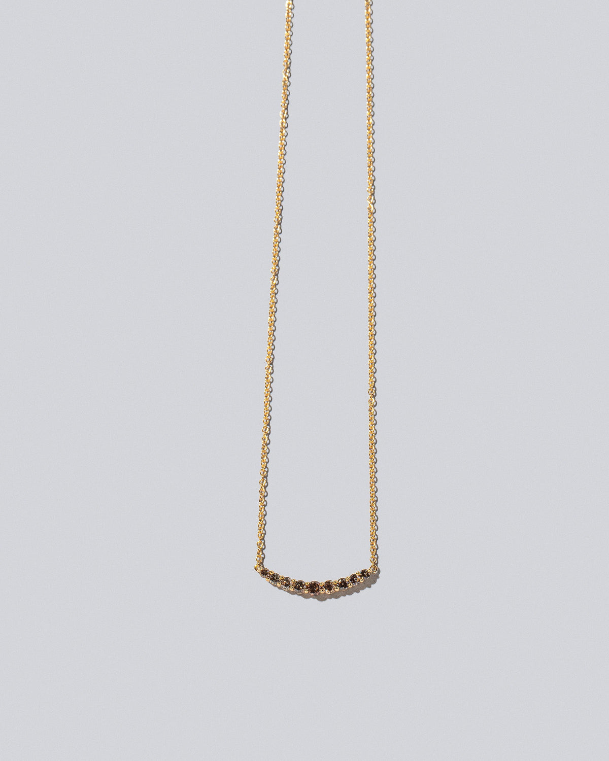 Cognac Diamond Crescent Necklace on light color background.