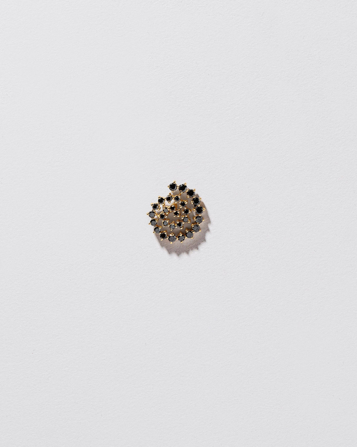Full Black Diamond Left Spiral Stud Earring Single on light color background.